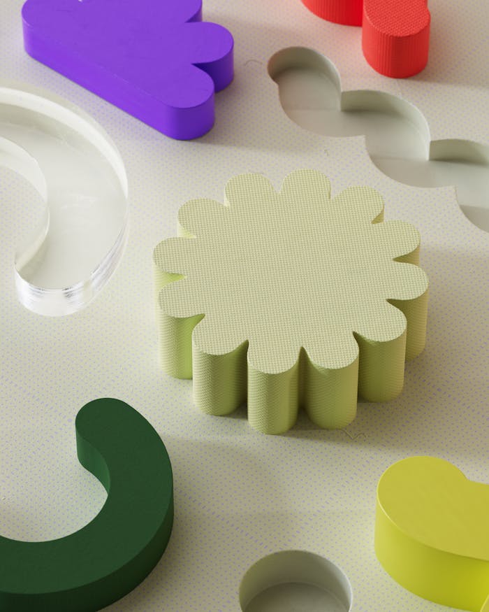 Vibrant abstract composition with colorful geometric 3D shapes on a textured surface.